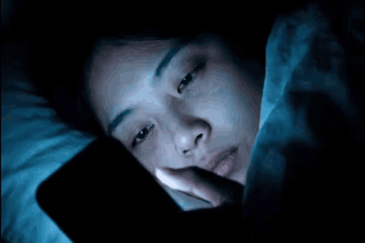 Woman lying awake in bed at night, unable to sleep