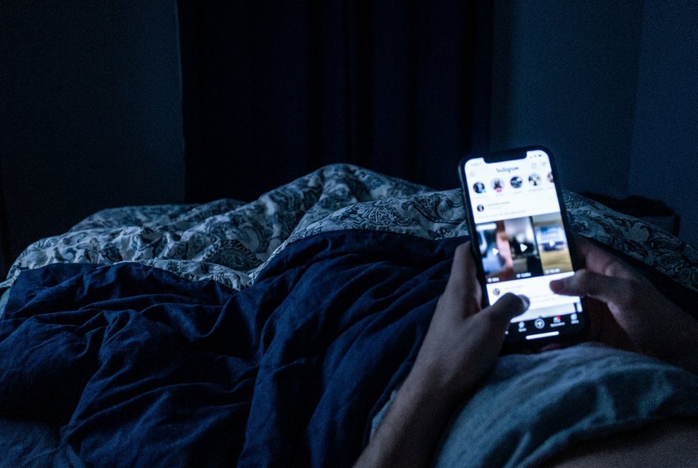 Scrolling phone in bed at night